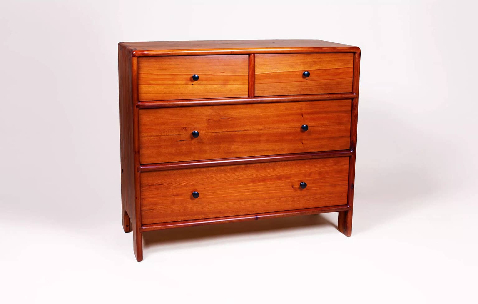 Front view of a four drawer solid wood dresser built from reclaimed redwood. The dresser is hand-joined at the top with dovetails and the remainder of the cabinet is assembed with sliding dovetails. The piece is solid wood and sits on legs that are molded from the sides of the cabinet.The entire piece was built using hand-tools by woodworker and furniture maker, Marc Springer in Los Angeles.