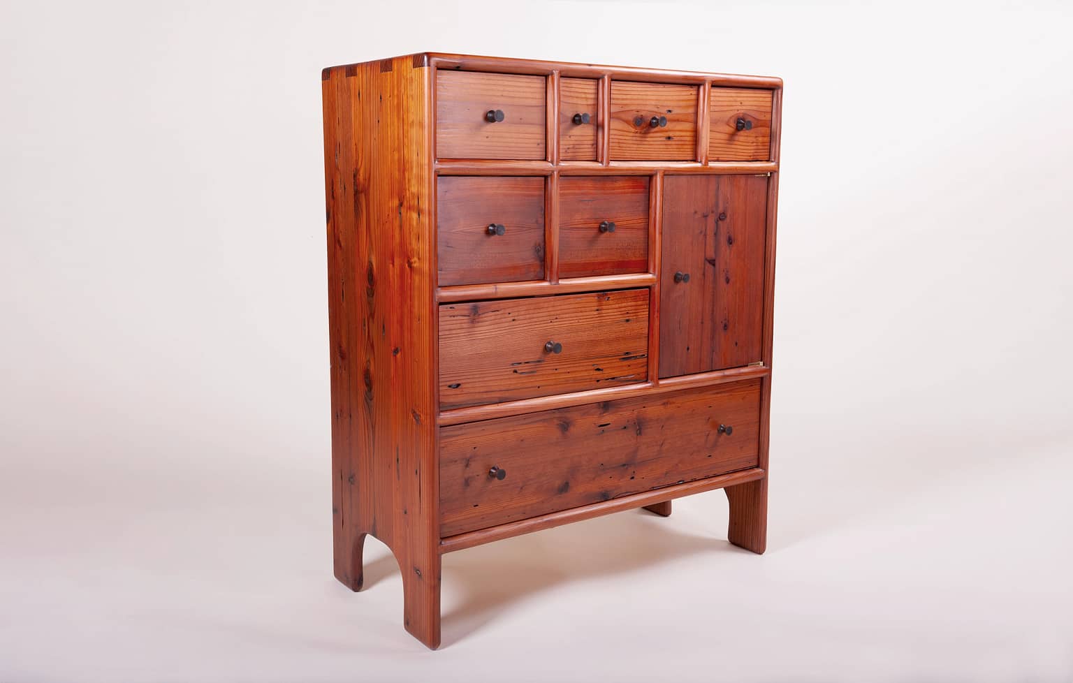 3/4 view of a free standing chest of drawers with a small cabinet space as well. The front of the cabinet has 8 drawers and the cabinet door. The cabinet is 36" high, 15" deep and 50" wide. It is made from reclaimed redwood. It is completely crafted by hand without power tools using only traditional joinery and techniques. It has 5 coats of hand rubbed finish for a satin sheen. The piece was designed and crafted by Marc Springer a furniture maker in Woodland Hills, California.