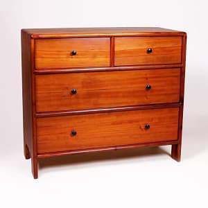 Front view of a four drawer solid wood dresser built from reclaimed redwood. The dresser is hand-joined at the top with dovetails and the remainder of the cabinet is assembed with sliding dovetails. The piece is solid wood and sits on legs that are molded from the sides of the cabinet.The entire piece was built using hand-tools by woodworker and furniture maker, Marc Springer in Los Angeles.