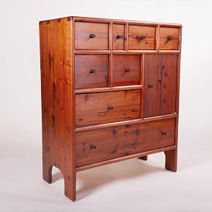 3/4 view of a free standing chest of drawers with a small cabinet space as well. The front of the cabinet has 8 drawers and the cabinet door. The cabinet is 36" high, 15" deep and 50" wide. It is made from reclaimed redwood. It is completely crafted by hand without power tools using only traditional joinery and techniques. It has 5 coats of hand rubbed finish for a satin sheen. The piece was designed and crafted by Marc Springer a furniture maker in Woodland Hills, California.